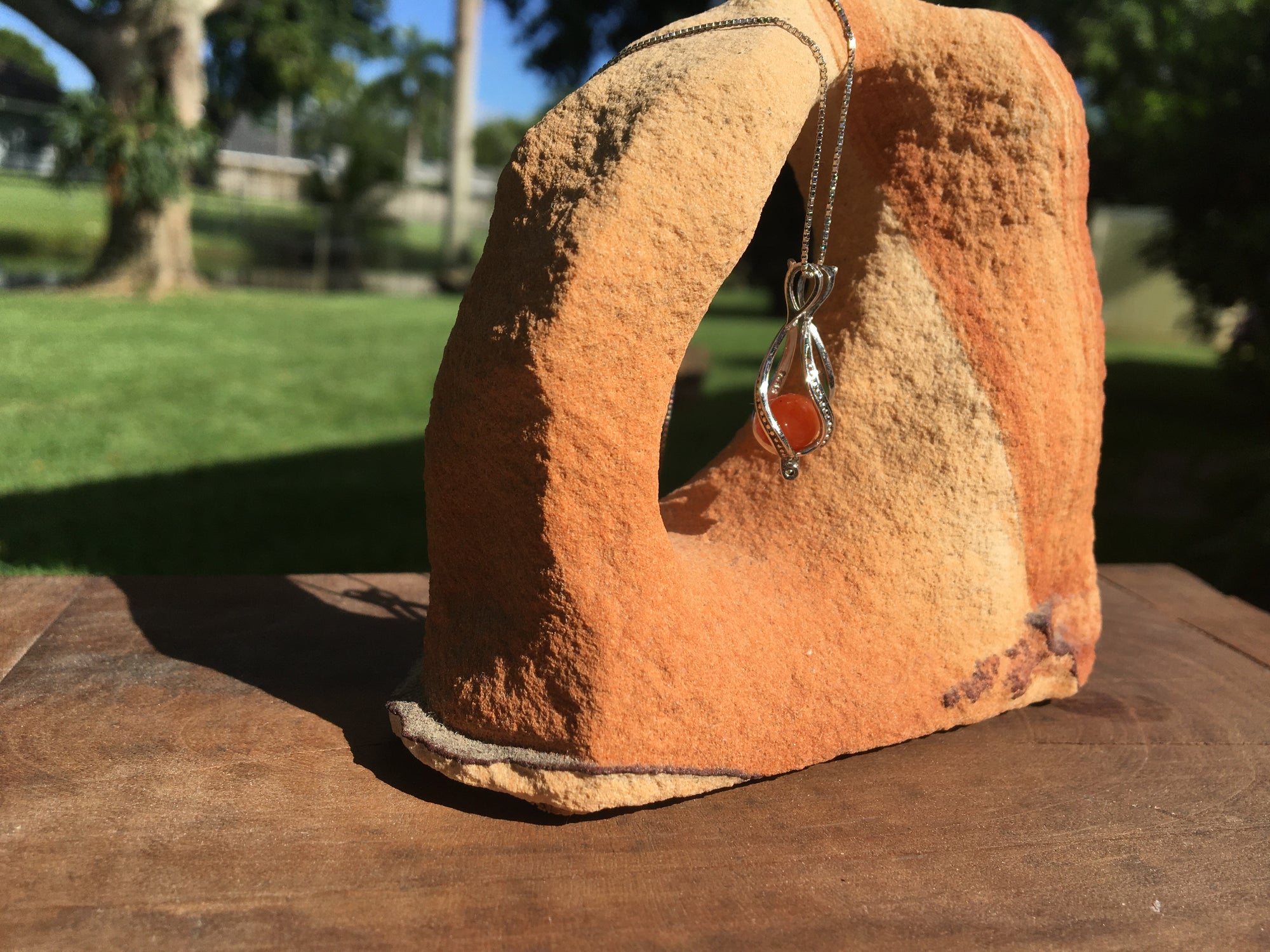 Sterling silver cage necklace with a 6mm Carnelian gemstone known for boosting willpower and drive