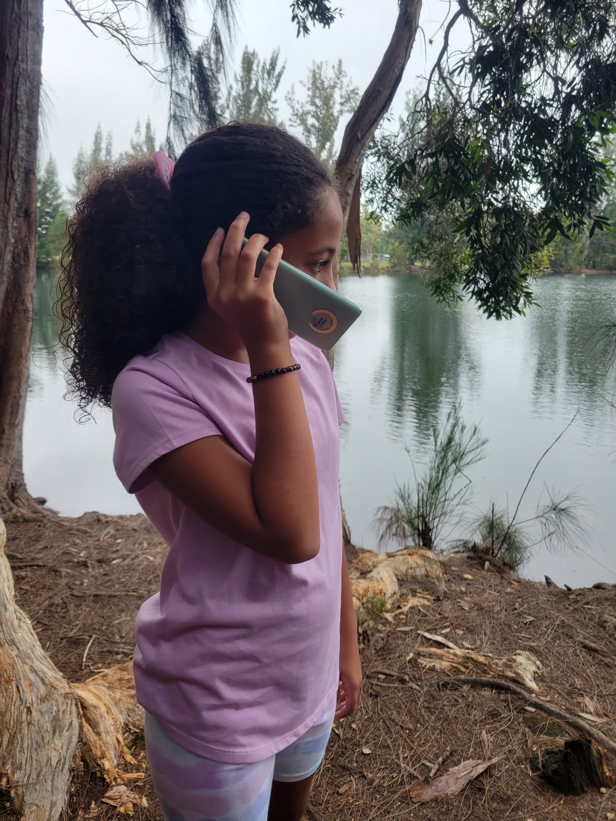 Good vibes cellphone sticker with shungite powder, protecting a young girl's cellphone from harmful EMF radiation