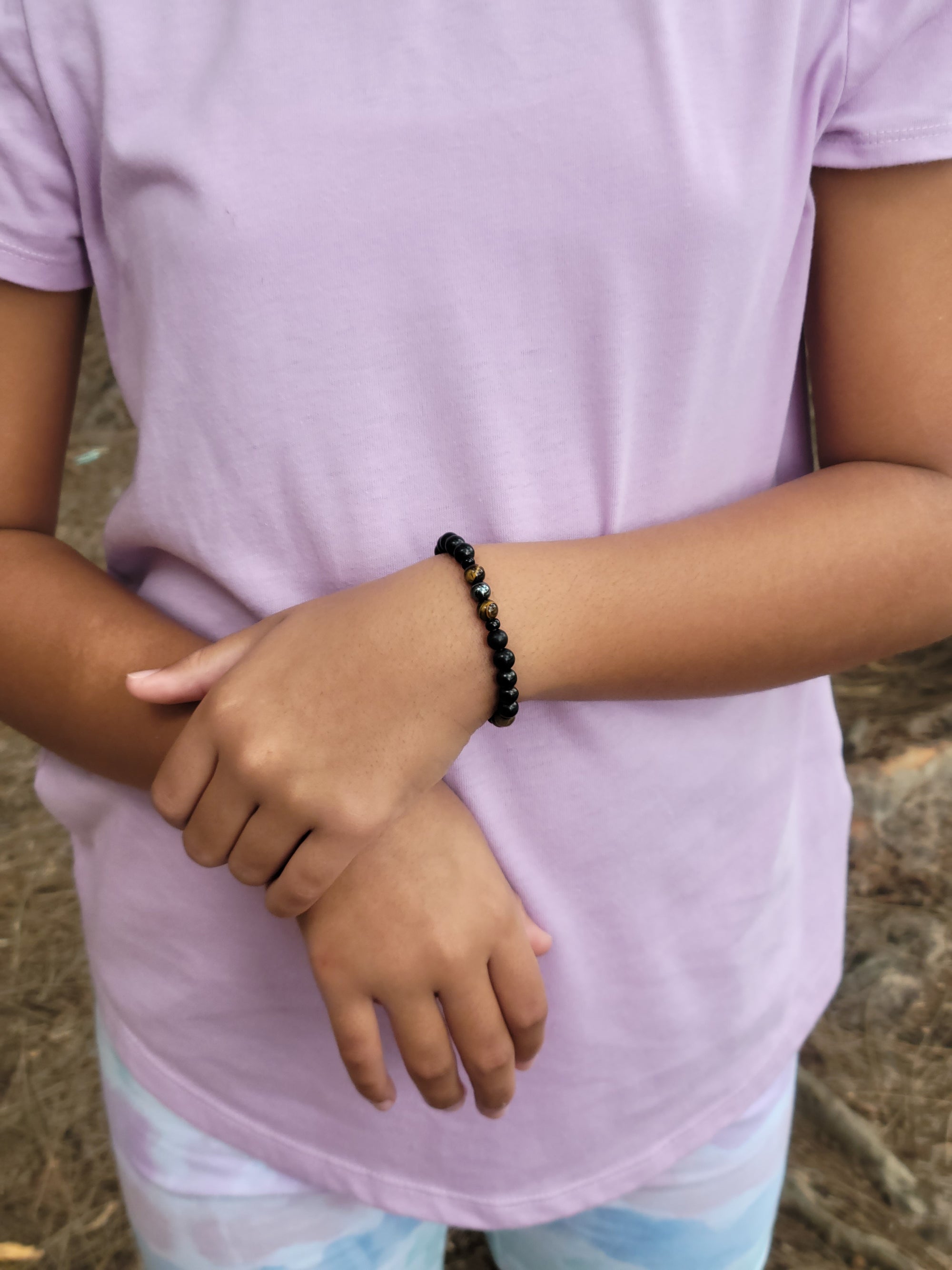 6mm shungite, tiger's eye, and hematite Triple Protection bracelet protecting a young girl