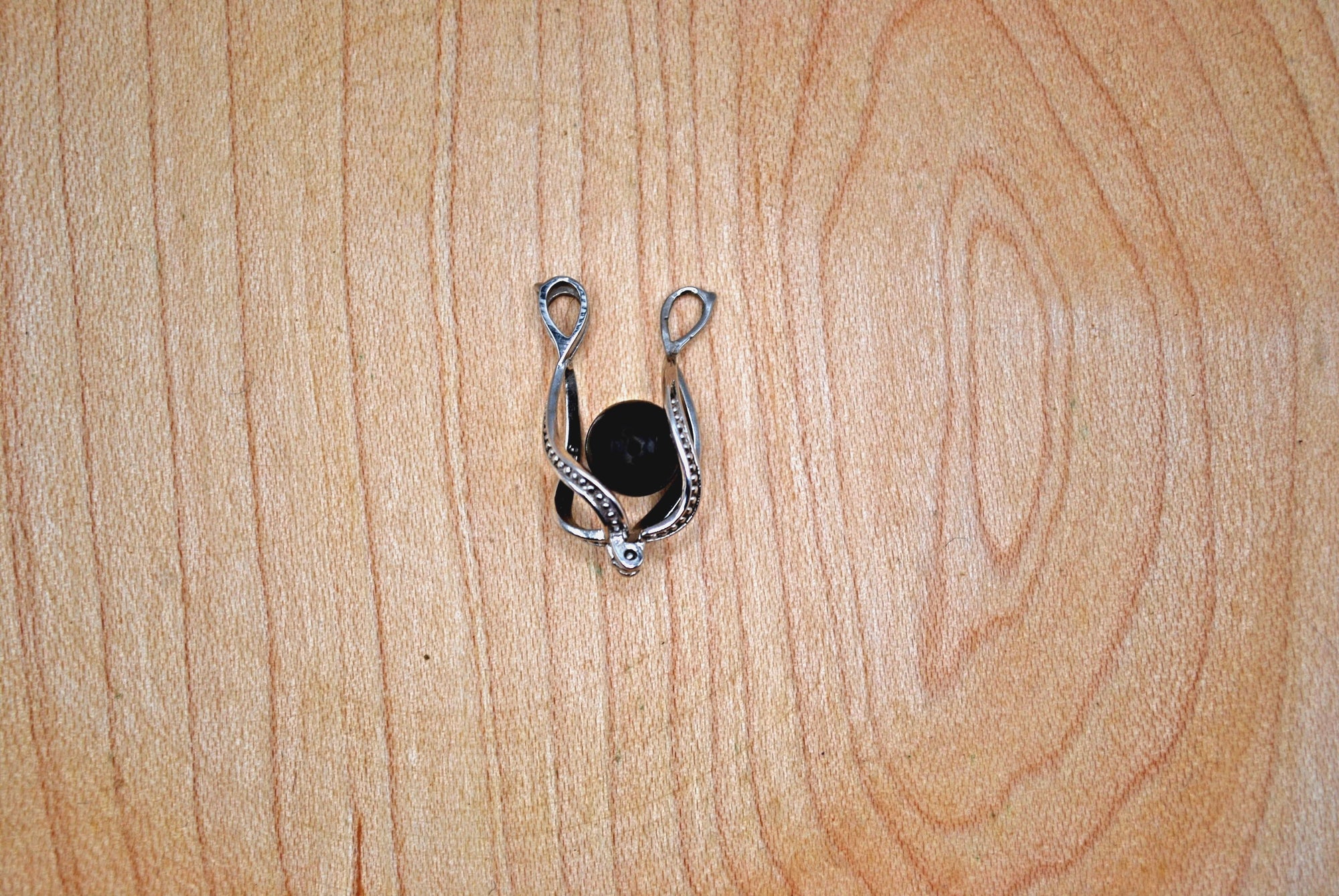 Sterling silver cage with a 6mm shungite stone open and ready to change out the stone inside, with 9 different options