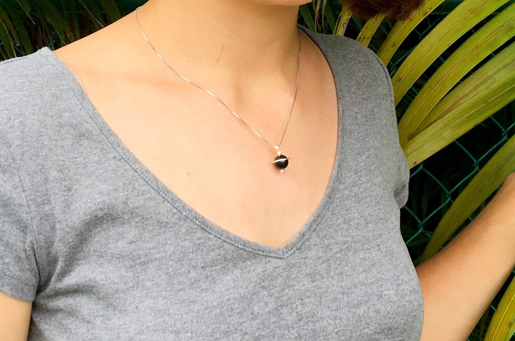 Young woman wearing the Shungite Orbit Pendant on a sterling silver chain