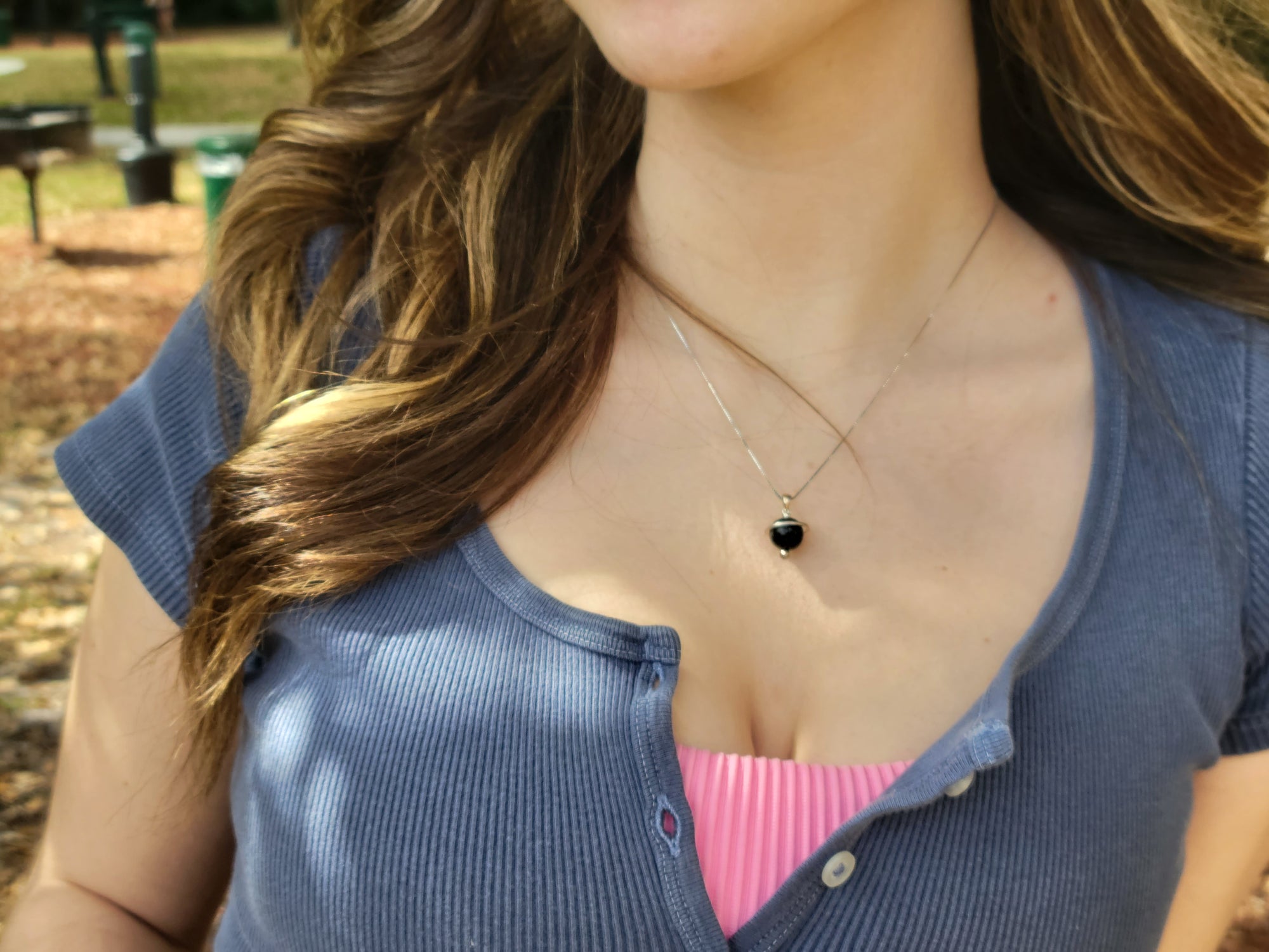 Young woman wearing the Shungite Orbit Pendant on a sterling silver chain