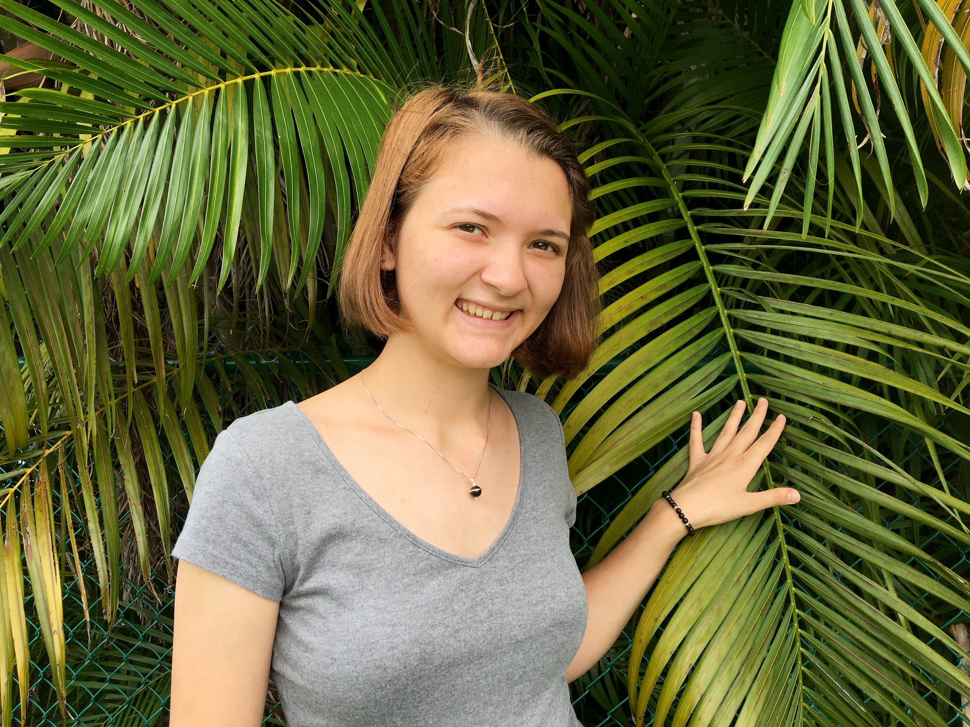 Young woman wearing the Shungite Orbit Pendant on a sterling silver chain