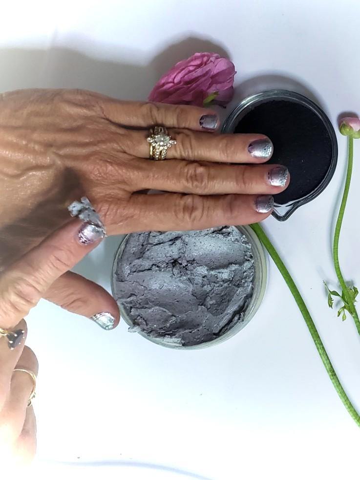 Woman applying lotion mixed with shungite powder onto her hand, to promote rejuvenation and reduce the effects of stress and anxiety 