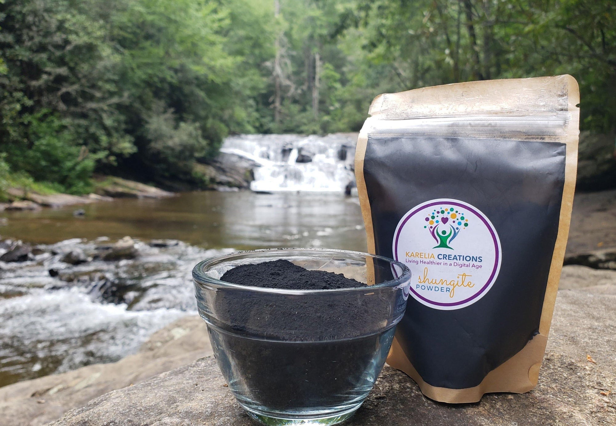 3 ounce package of authentic shungite powder for mixing, next to a cup of shungite powder in nature