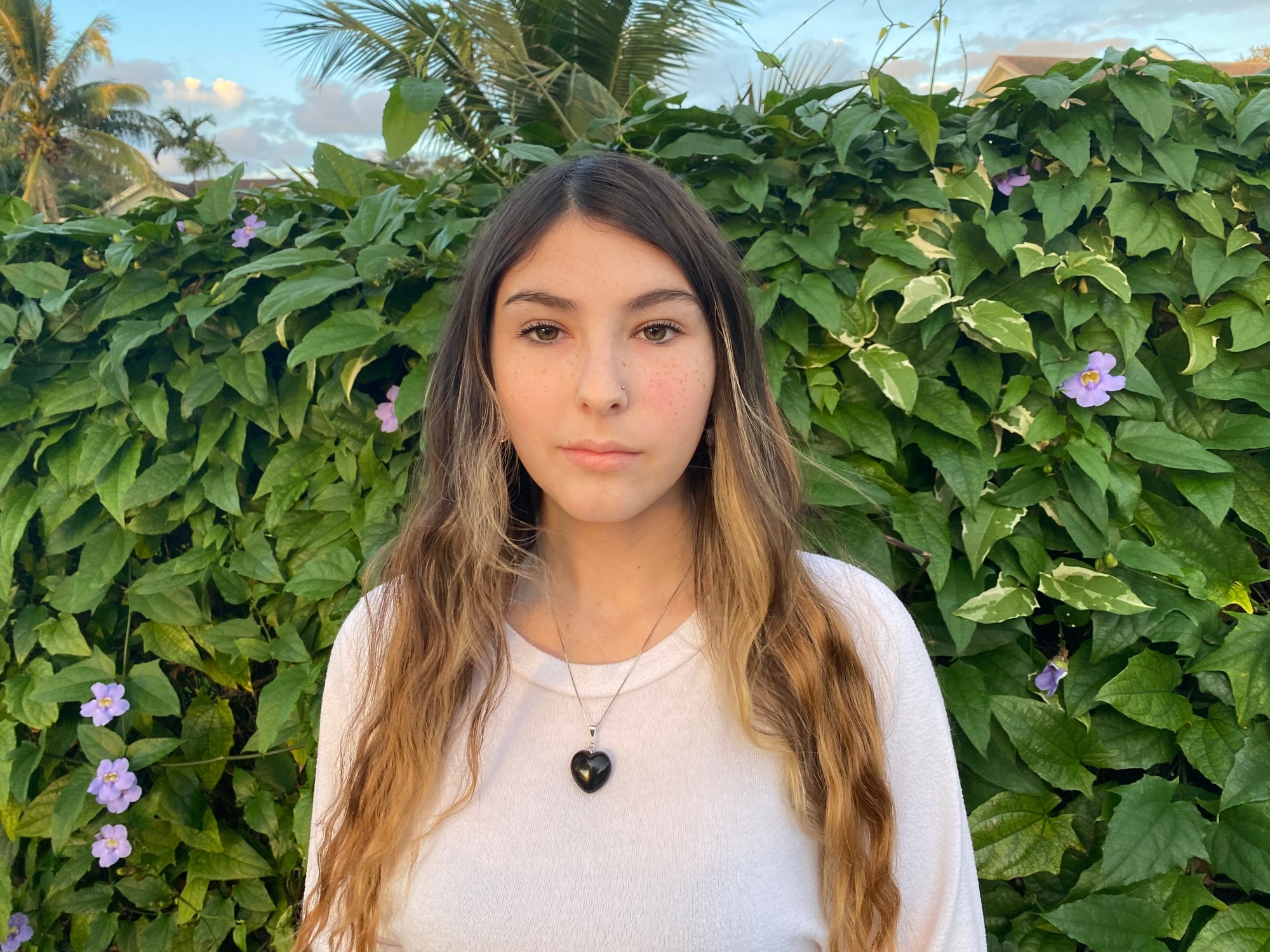 Young woman brings style, love, and protection to her outfit while wearing the puffy heart pendant on a sterling silver chain