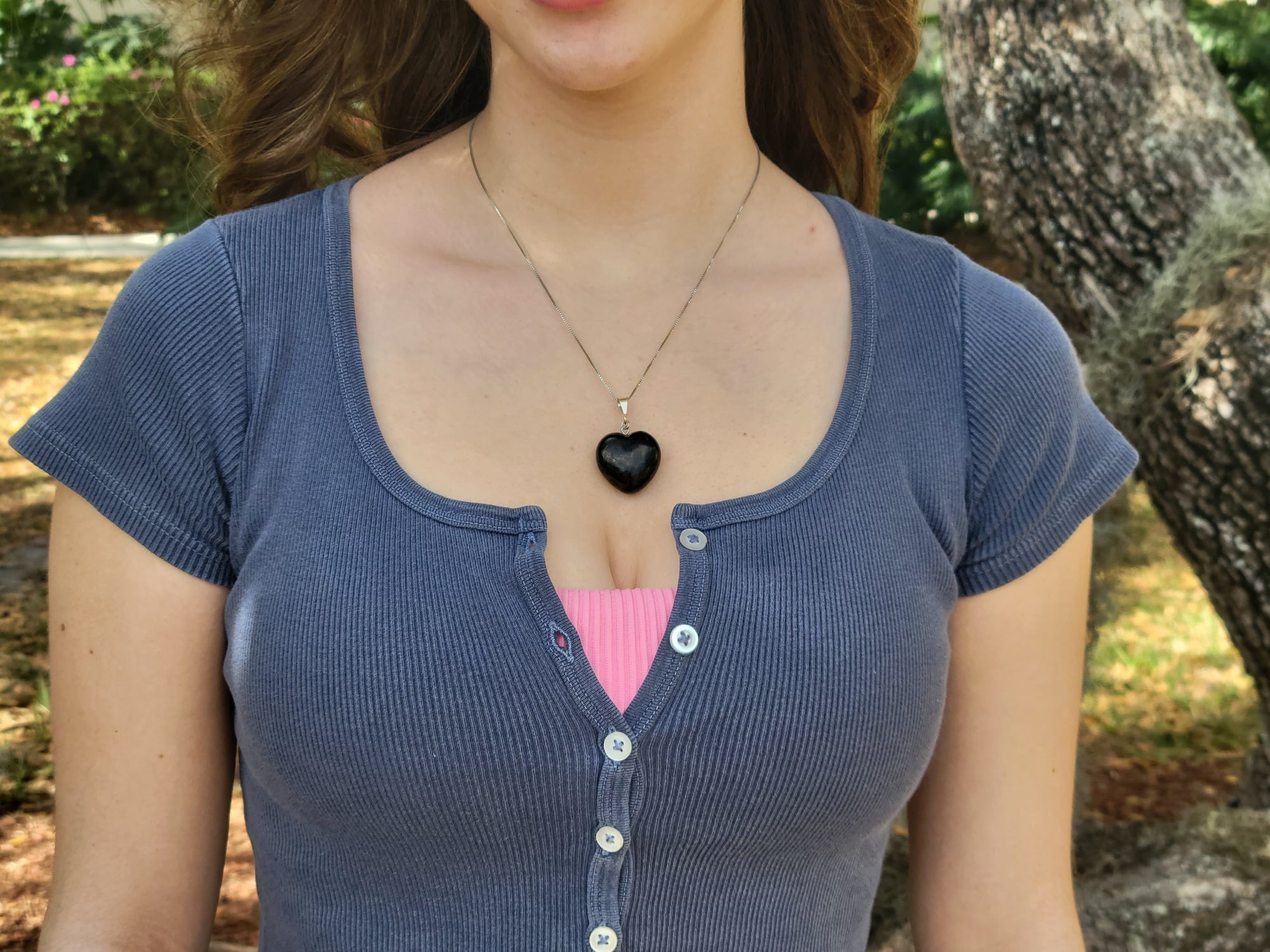 Young woman brings style, love, and protection to her outfit while wearing the puffy heart pendant on a sterling silver chain