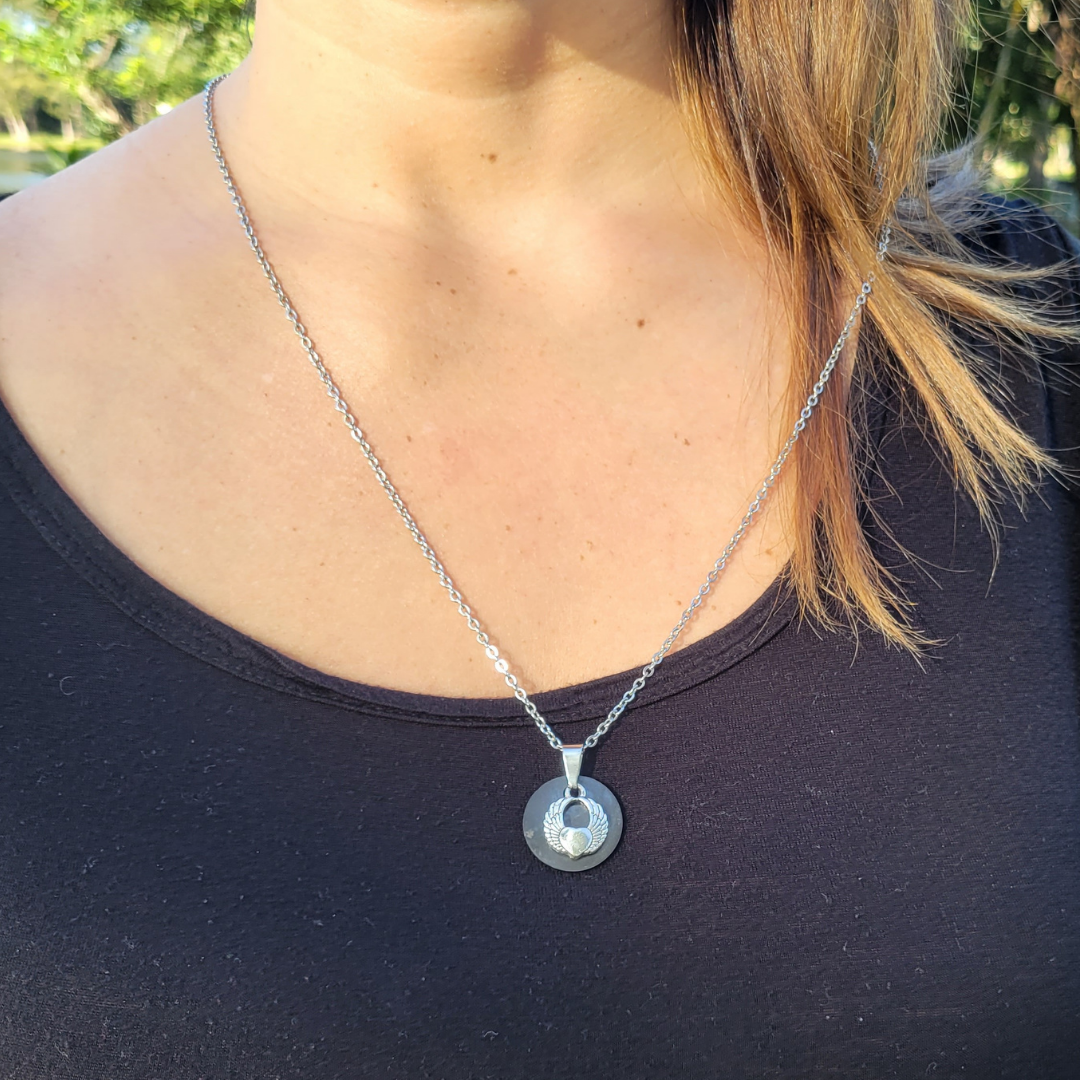 Shungite Pendant Necklace with an angel wing charm on a stainless steel chain modeled by a woman 