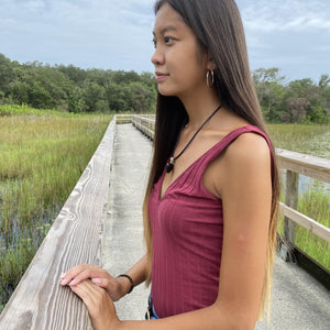 Young woman brings style, love, and protection to her outfit while wearing the puffy heart pendant on a leather cord